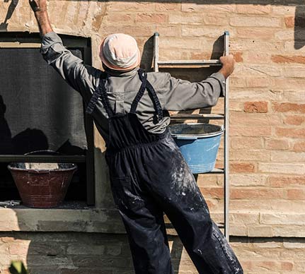 maçon qui répare une fissure et fait la restauration du  mur